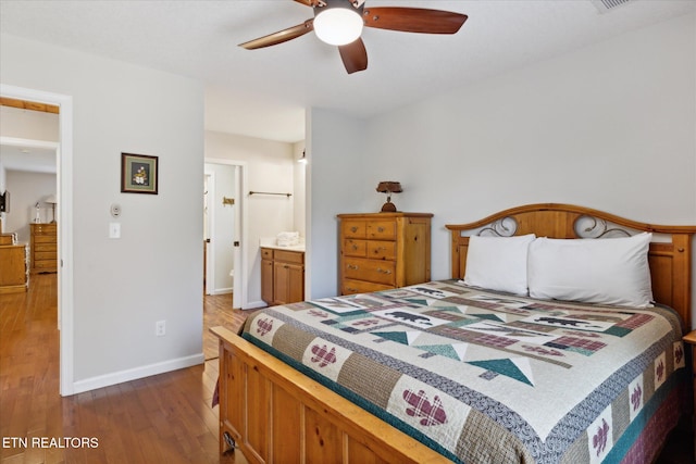 bedroom with ensuite bathroom, hardwood / wood-style flooring, and ceiling fan