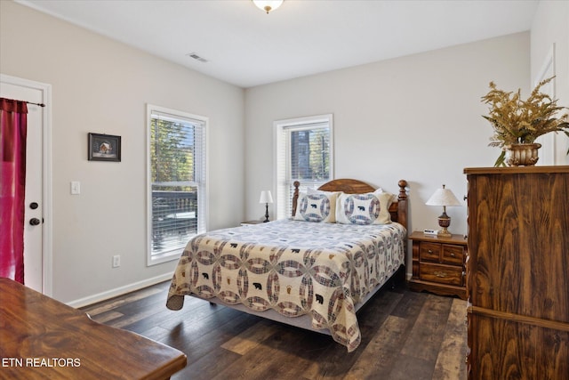 bedroom with multiple windows and dark hardwood / wood-style flooring