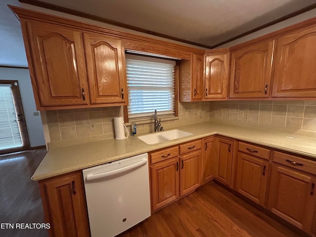 kitchen featuring white dishwasher, sink, hardwood / wood-style floors, and backsplash