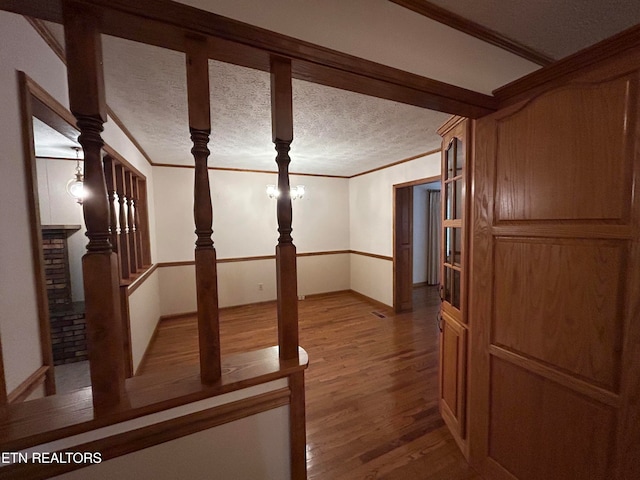 interior space featuring crown molding, light hardwood / wood-style flooring, and a textured ceiling