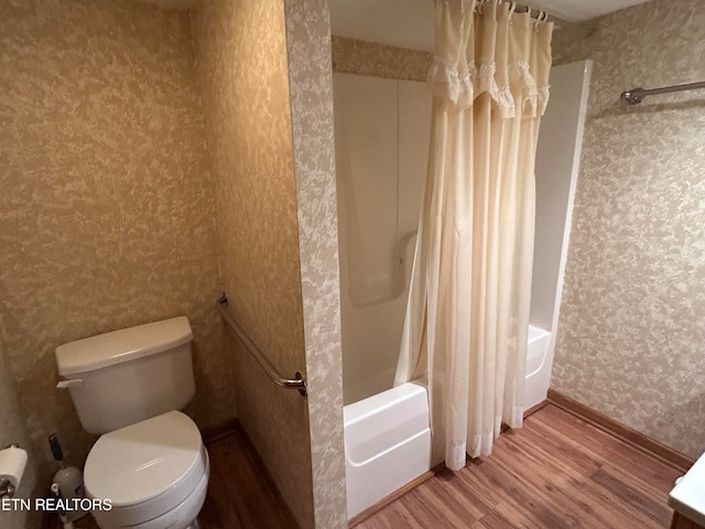 bathroom featuring toilet, hardwood / wood-style flooring, and shower / tub combo