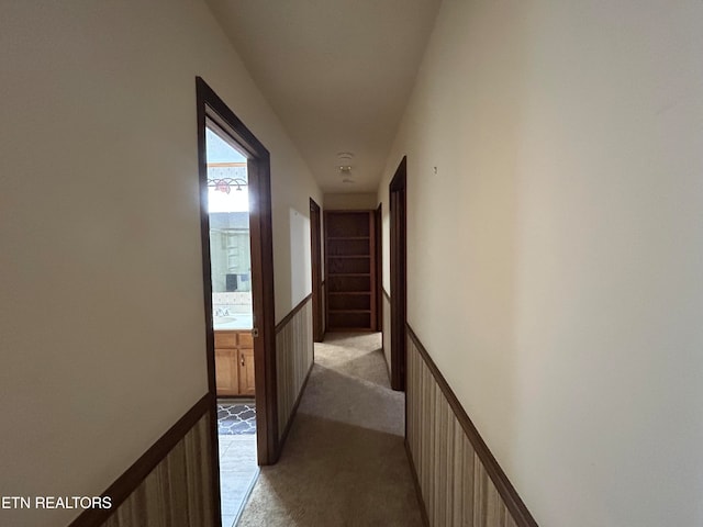 hall with light carpet and sink