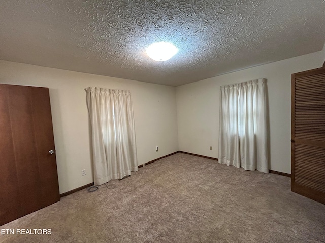 unfurnished bedroom with a textured ceiling and carpet floors