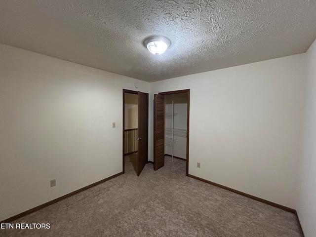 unfurnished bedroom featuring a closet, carpet, and a textured ceiling