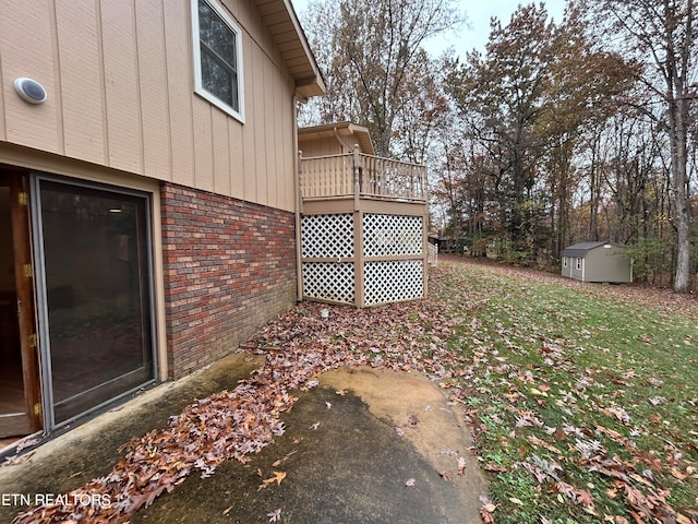 view of yard featuring a balcony and a storage shed