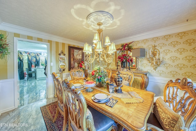 dining space featuring ornamental molding, a chandelier, and a textured ceiling