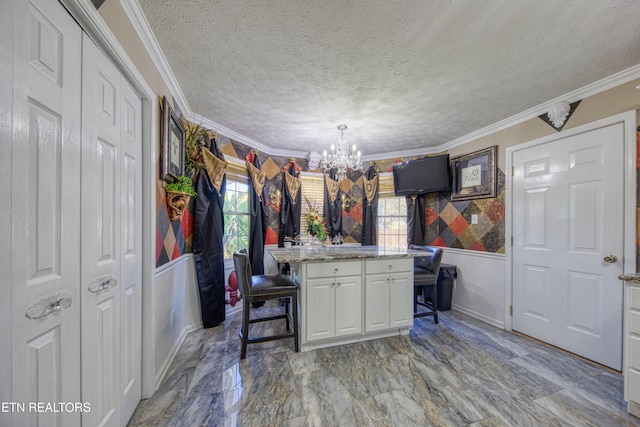 kitchen featuring a kitchen island, a breakfast bar area, white cabinetry, ornamental molding, and decorative light fixtures