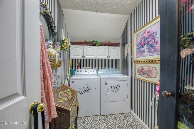 laundry area featuring cabinets, a textured ceiling, and washer and clothes dryer