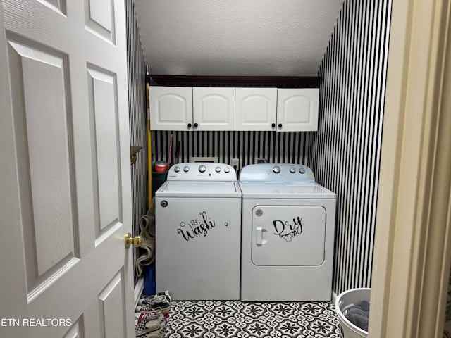 clothes washing area featuring a textured ceiling, independent washer and dryer, cabinet space, and tile patterned floors