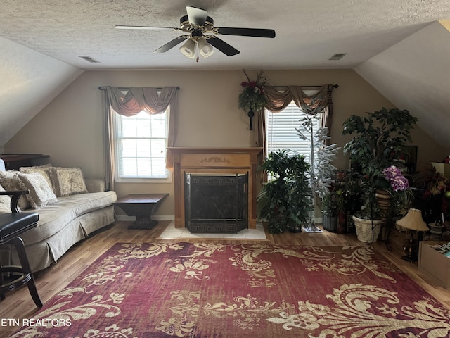 living room with light wood finished floors, visible vents, and a textured ceiling