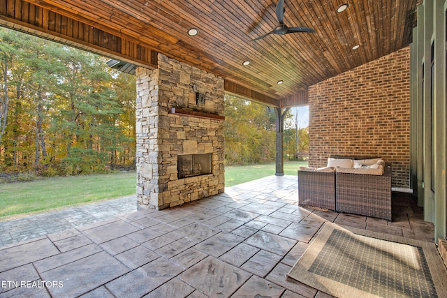 view of patio / terrace with an outdoor living space with a fireplace and ceiling fan