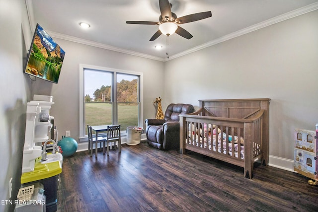 bedroom featuring ornamental molding, a nursery area, dark hardwood / wood-style floors, and ceiling fan