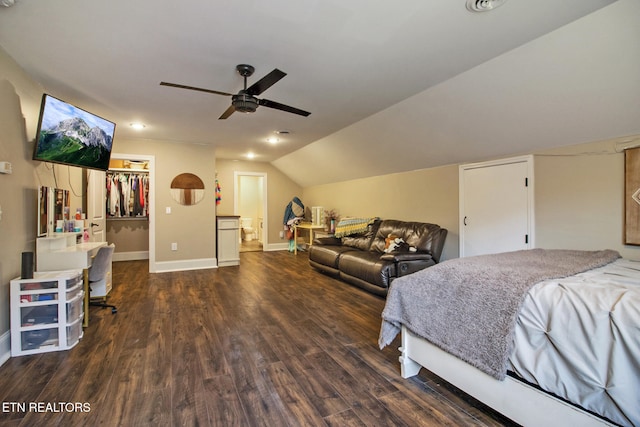 bedroom with a walk in closet, a closet, ceiling fan, vaulted ceiling, and dark hardwood / wood-style floors