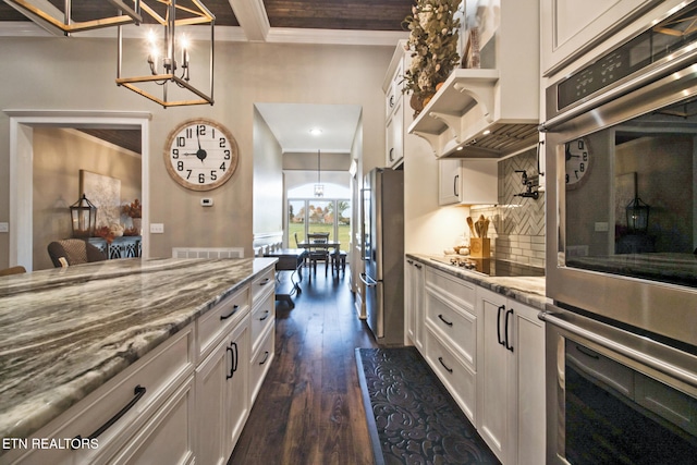 kitchen with white cabinets, dark hardwood / wood-style flooring, backsplash, light stone countertops, and stainless steel appliances