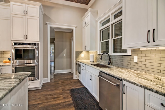 kitchen with sink, stainless steel appliances, white cabinets, decorative backsplash, and dark hardwood / wood-style floors