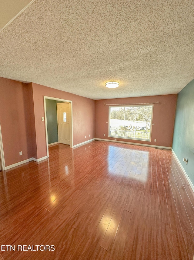 spare room featuring hardwood / wood-style flooring and a textured ceiling