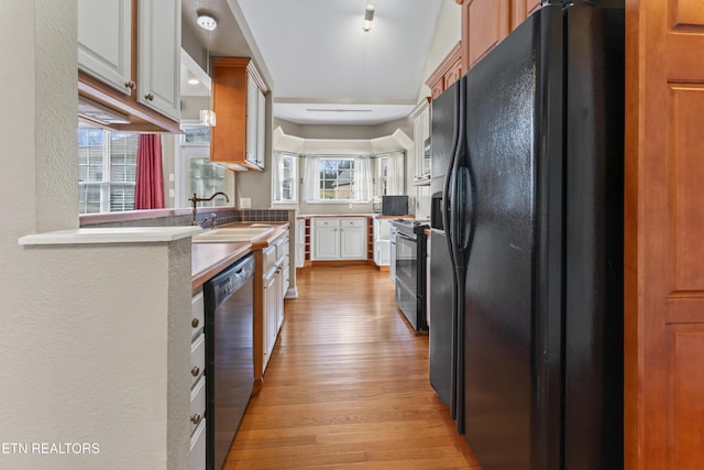 kitchen with light hardwood / wood-style floors, sink, white cabinets, and stainless steel appliances