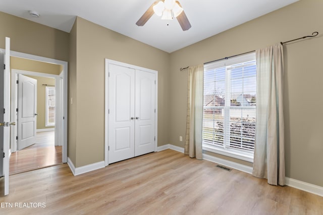 unfurnished bedroom with ceiling fan, light hardwood / wood-style floors, and a closet