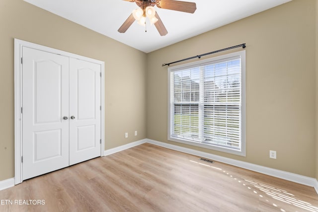 unfurnished bedroom featuring ceiling fan, a closet, and light hardwood / wood-style flooring