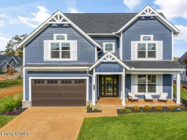 craftsman inspired home featuring a front yard and a garage