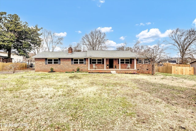 view of front of property featuring fence, covered porch, crawl space, brick siding, and a chimney