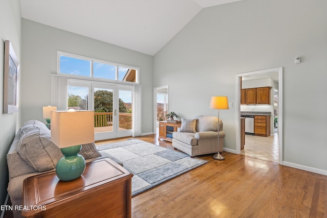 living room with light hardwood / wood-style flooring and high vaulted ceiling