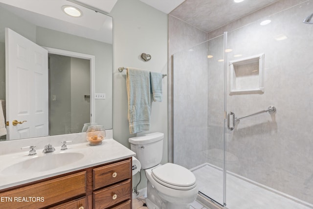 bathroom with vanity, toilet, and a shower with door