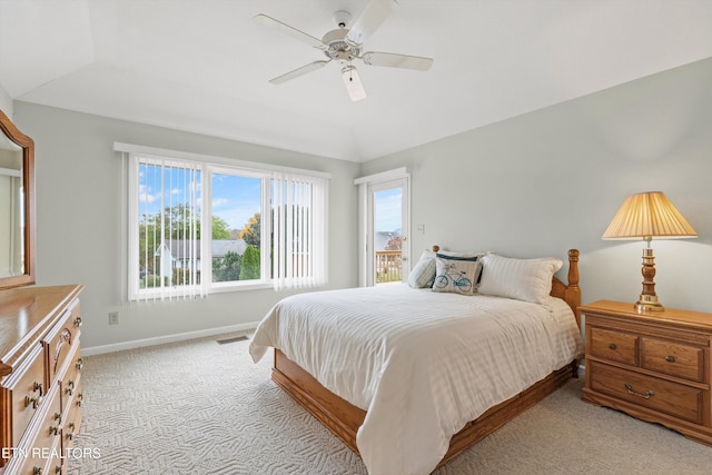 bedroom featuring a raised ceiling, ceiling fan, light carpet, and lofted ceiling