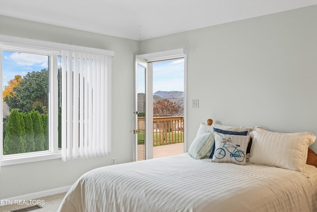 carpeted bedroom featuring a mountain view and access to outside