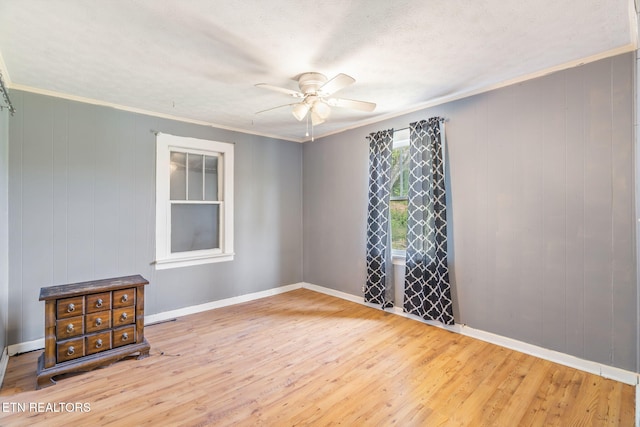 spare room featuring ceiling fan, ornamental molding, and wood-type flooring