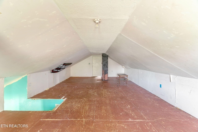 bonus room featuring vaulted ceiling and a textured ceiling