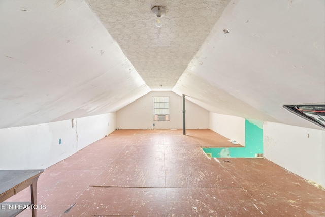 bonus room featuring lofted ceiling and a textured ceiling