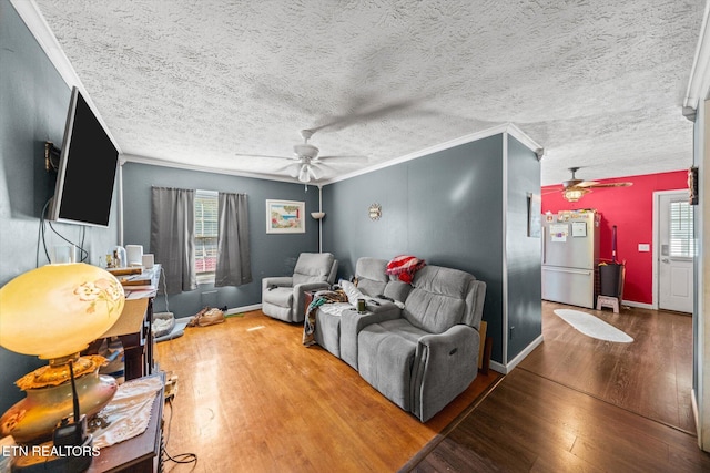 living room featuring crown molding, a textured ceiling, wood-type flooring, and ceiling fan