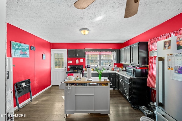 kitchen with sink, black appliances, dark hardwood / wood-style floors, and a textured ceiling