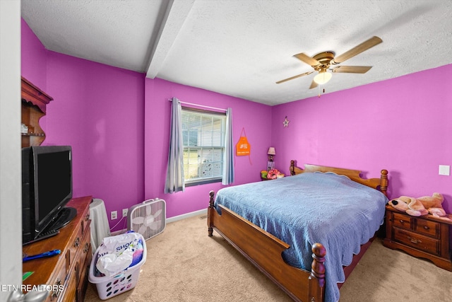 bedroom featuring beamed ceiling, light carpet, a textured ceiling, and ceiling fan