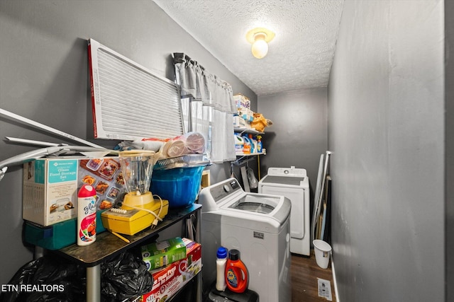 clothes washing area featuring washer and dryer, hardwood / wood-style flooring, and a textured ceiling