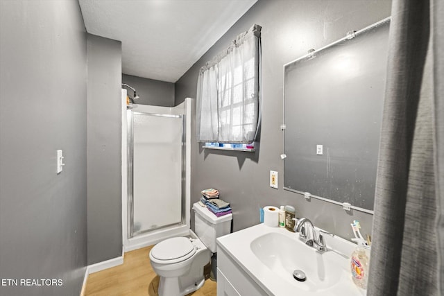 bathroom with a textured ceiling, an enclosed shower, hardwood / wood-style floors, toilet, and vanity