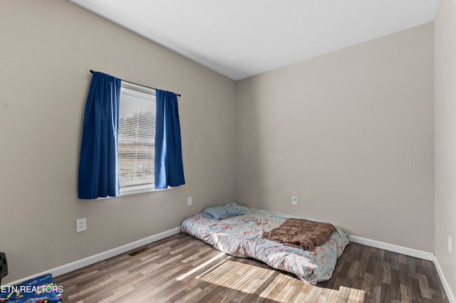 bedroom with dark hardwood / wood-style floors