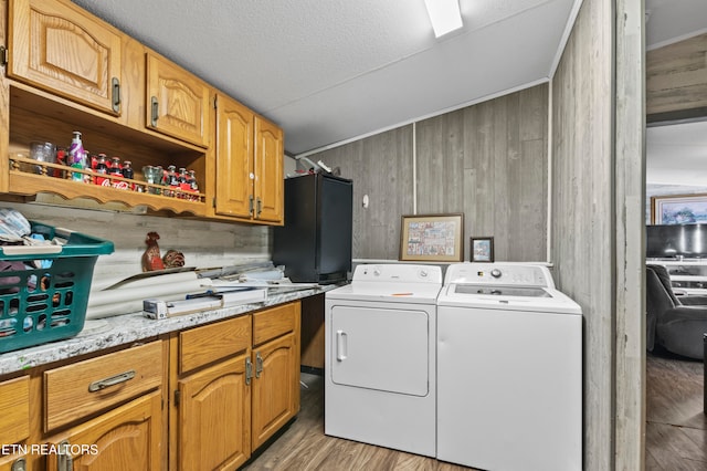 laundry room with wood walls and light hardwood / wood-style flooring