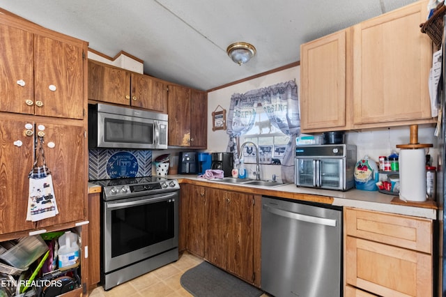 kitchen featuring sink, stainless steel appliances, crown molding, a textured ceiling, and vaulted ceiling