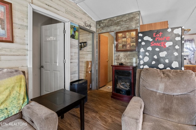 living room featuring a fireplace, wood walls, lofted ceiling, and dark wood-type flooring