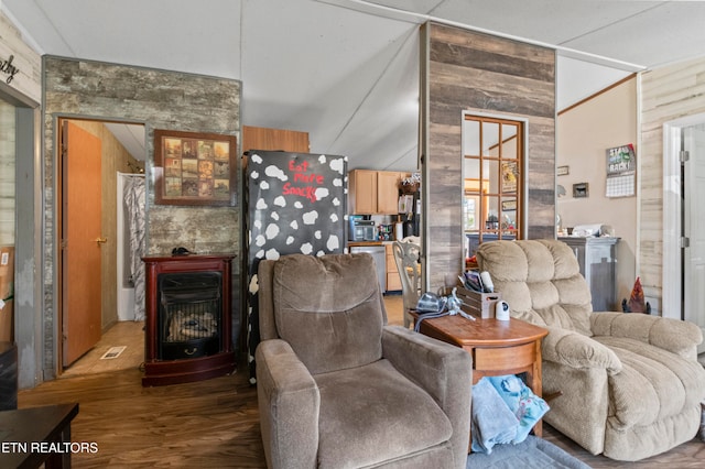 living room with hardwood / wood-style floors, vaulted ceiling, and wood walls