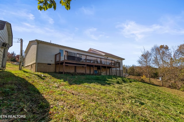 back of property featuring a lawn and a wooden deck