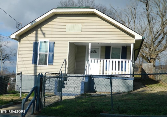 bungalow-style home with covered porch and a front lawn