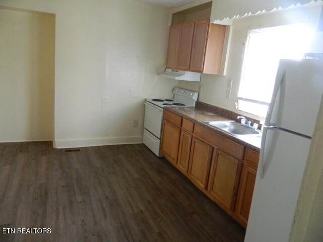 kitchen with sink, dark wood-type flooring, and white appliances