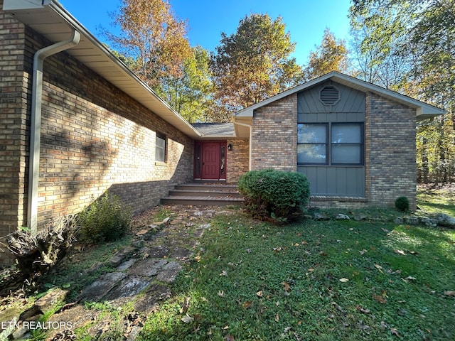 doorway to property featuring a lawn