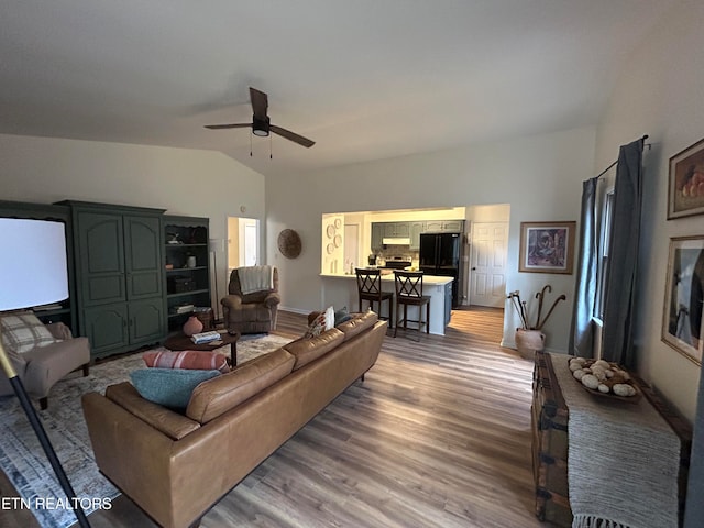 living room with lofted ceiling, hardwood / wood-style floors, and ceiling fan