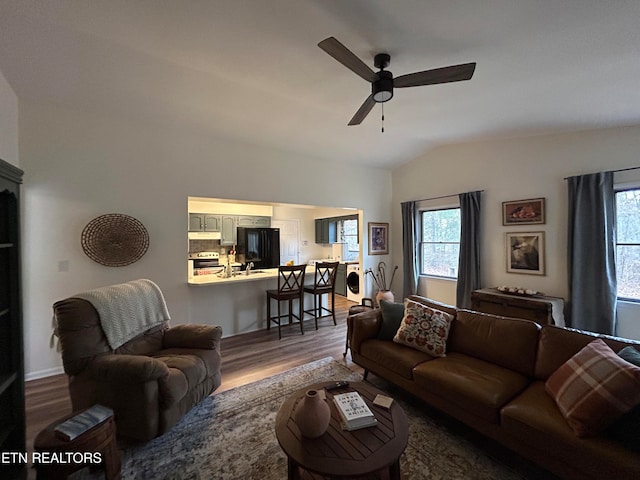 living room with ceiling fan, wood-type flooring, and vaulted ceiling