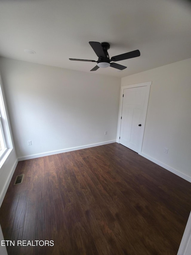 empty room featuring ceiling fan and dark hardwood / wood-style flooring