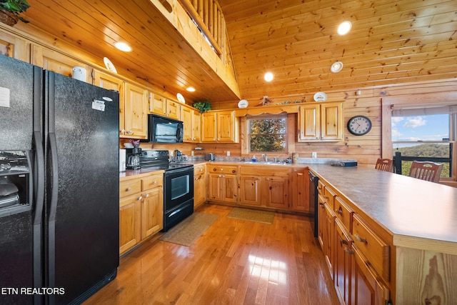 kitchen with wood ceiling, light wood-type flooring, wood walls, black appliances, and sink